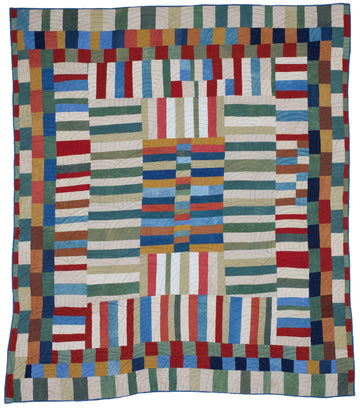 improvisational patchwork made with naturally-dyed colors: red, orange, brown, blue, and green contrasted with pastel blue, green and beige.